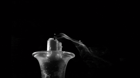 smoke emanates from the wick of a candle